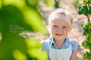 Michigan family lifestyle photography in a hop yard with the most adorable triplets. Great kids outfit ideas and a unique picture location idea.