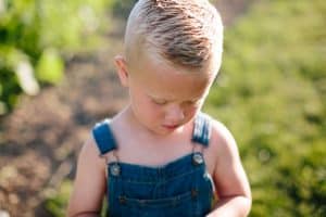 A day in the life photography session at the families farmhouse in Michigan with triplets, adorable kids fashion, goats, chickens, and fresh vegetables.