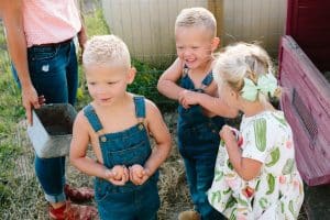 A day in the life photography session at the families farmhouse in Michigan with triplets, adorable kids fashion, goats, chickens, and fresh vegetables.