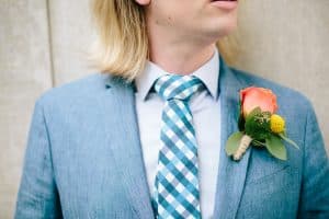 Mens bright orange boutonniere one a blue suite coat for a Grand Rapids Wedding.