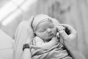 A newborn lifestyle session in a photography studio in Grand Rapids with a dog.