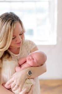 A newborn lifestyle session in a photography studio in Grand Rapids with a dog.