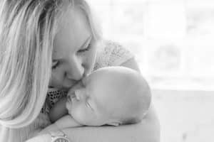 A newborn lifestyle session in a photography studio in Grand Rapids with a dog.