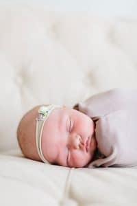 A newborn lifestyle session in a photography studio in Grand Rapids with a dog.