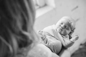 A newborn lifestyle session in a photography studio in Grand Rapids with a dog.