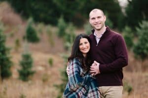 A family photo session with a family of three at a Christmas Tree Farm in Alto Michigan at Postema Christmas Tree Farm.