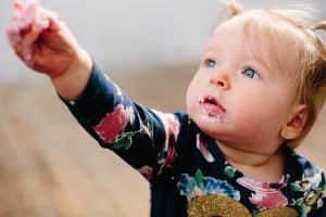 A baby girl turns one and has a cake smash during her photo shoot.