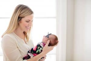 A mom with her newborn girl during an in home newborn session in Grand Rapids.