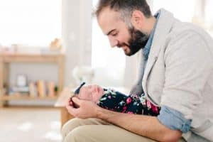 A dad with his newborn girl during an in home newborn session in Grand Rapids.