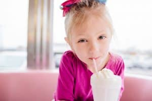 A Grand Rapids kids photoshoot in a pink diner with a milkshake.
