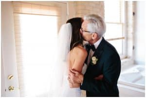 Bride getting a kiss from her father before the wedding ceremony