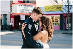 Bride and groom in front of a movie theater in downtown Grand Haven