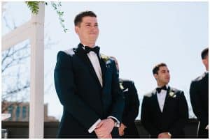 Groom smiling as he waits for his bride to walk down the isle