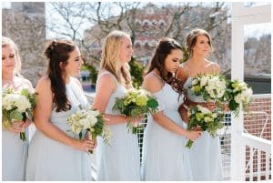 Bridesmaids dressed in long light blue dresses standing at the alter