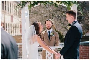 Bride and groom standing in front of the minister and laughing as they share vows