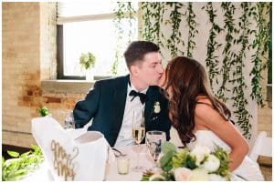 Bride and groom kissing at the Harbourfront Place while eating during their reception
