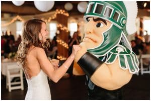 Bride dances with the Michigan Sate mascot during her reception