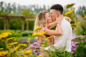 Cherry Point Farms engagement photography session in the bright flowers in the summer where couple is kissing