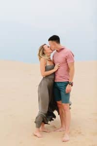 Couple kissing at Silver Lake Sand Dunes for their engagement photos