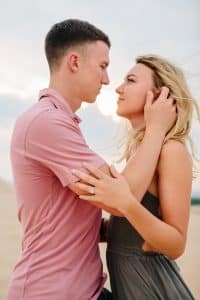 Couple looking each other in the eyes while standing on the Dunes at Silver Lake.