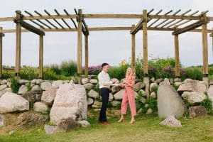 Outdoor Engagement photography session at Cherry Point Farms where couple is laughing and holding hands under a wooden archway