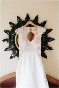 Wedding dress hanging in front of a black mirror to be on display for Wedding Pictures