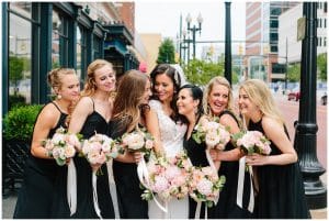 The Bride and her bridesmaids laughing and smiling outside downtown Grand Rapids