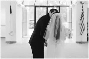 After the ceremony the bride and groom share a kiss outside in the hall of the church