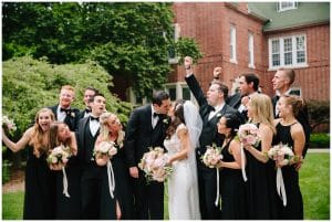 The wedding party and the bride and groom stand outside of a beautiful historic building in Grand Rapids, Michigan.