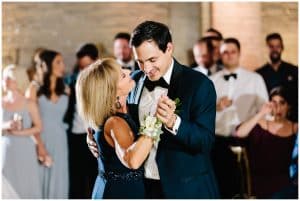 A groom dances with his mother at the wedding reception.