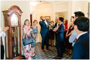 A soon to be bride and groom welcome their guests into the small ceremony space as they prepare for the first of two ceremonies.