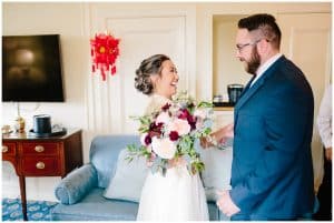 A soon to be bride and groom see each other dressed up for the first time and exchange happy glances.