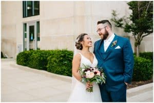 A bride and groom smile at each other before the wedding ceremony.