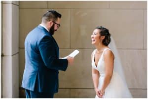 A bride and groom share letters to each other under a pretty building in Grand Rapids, Michigan.
