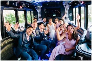 The bridal party travels to the wedding ceremony in a fancy party vehicle.