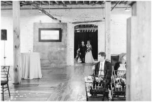 A picture of the bride being brought into the wedding ceremony by her father.