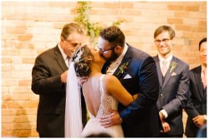 A picture of a bride and groom kissing after sharing their vows.