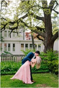 A couple dips under a tree at the U of M campus to kiss for their engagement photo session with Mae Photo Co.