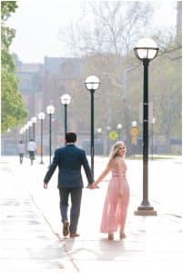 A couple takes a walk on the streets of U of M for their engagement photos taken by Mae Photo Co.
