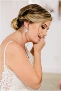 A bride puts on her earrings to match her wedding dress.