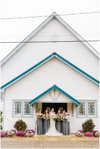 A bride and her bridesmaids in front of Holly Vault Chapel on the brides wedding day.