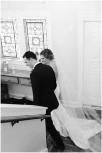 Black and white image of a bride and groom walking down the stairs after their wedding ceremony
