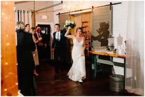 A bride and groom are introduced to their guests at the reception for the first time.