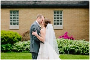 A bride and groom kiss during their first look photos.
