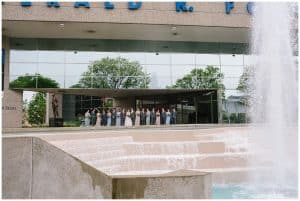 An image of the bridal party posing near downtown Grand Rapids in front of a water display.