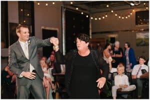 A groom shares a dance with his mother at his wedding reception.