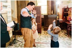 A groom and a ring bearer share a special handshake at the beginning of the wedding ceremony.