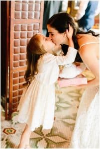 A bride leans down for a special kiss from her daughter.