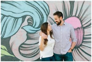 A couple with their arms around each other for their downtown engagement photo session