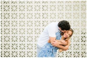 An engaged couple poses in front of a unique and beautiful textured white wall in Grand Rapids, Michigan.